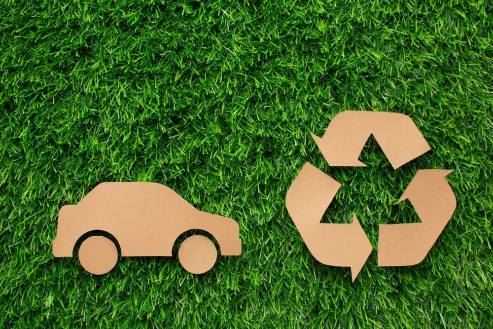 Car recycling sign in grass representing responsible vehicle disposal